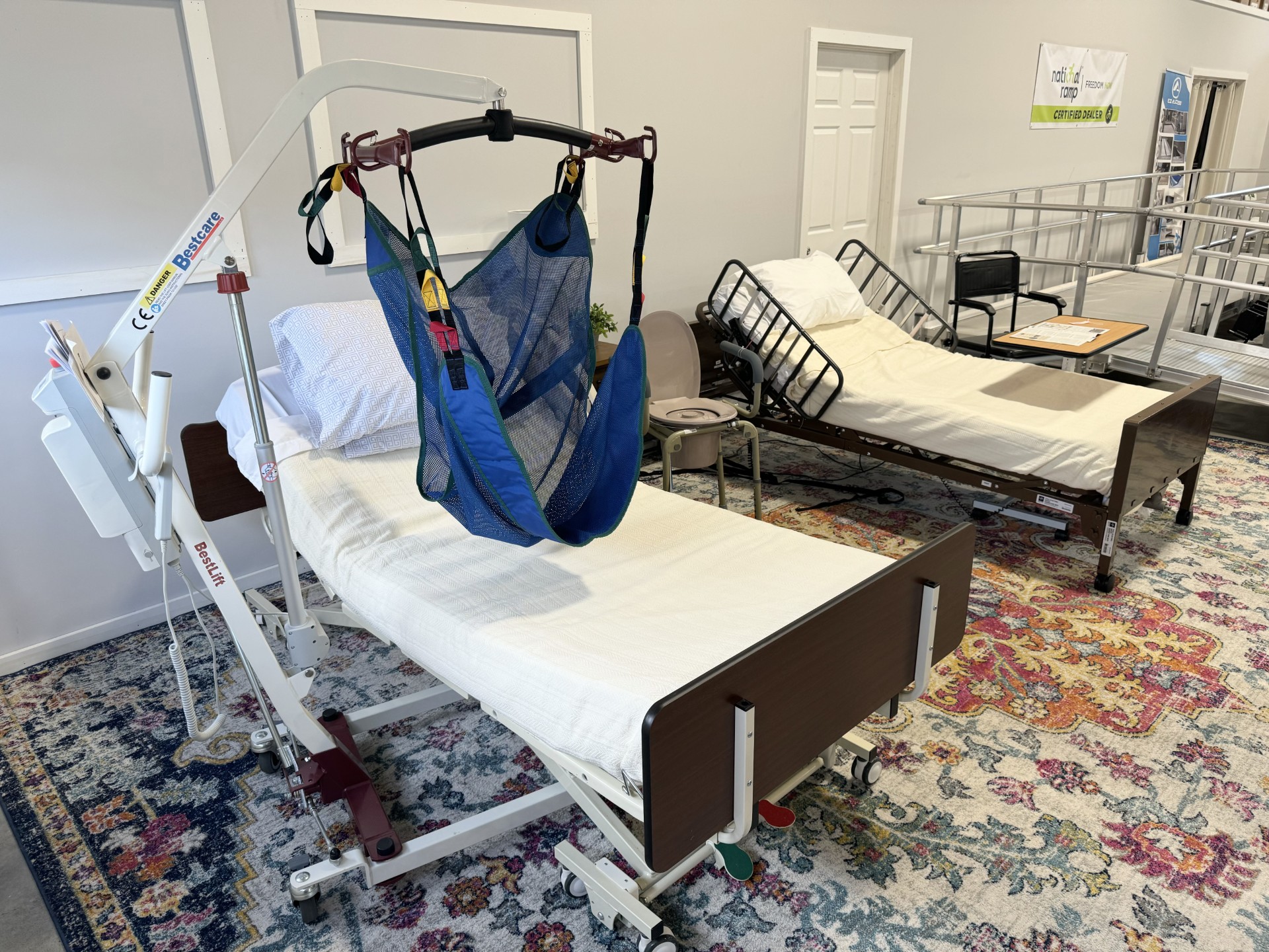Adjustable hospital bed with a Hoyer patient lift at the Upward Mobility showroom